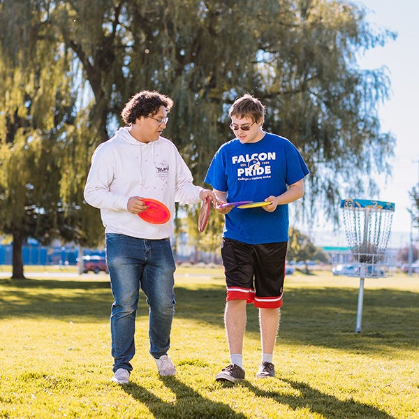 students playing disc golf