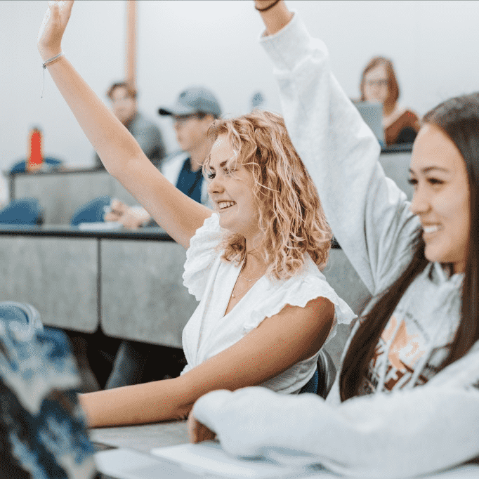 Two students raising their hands