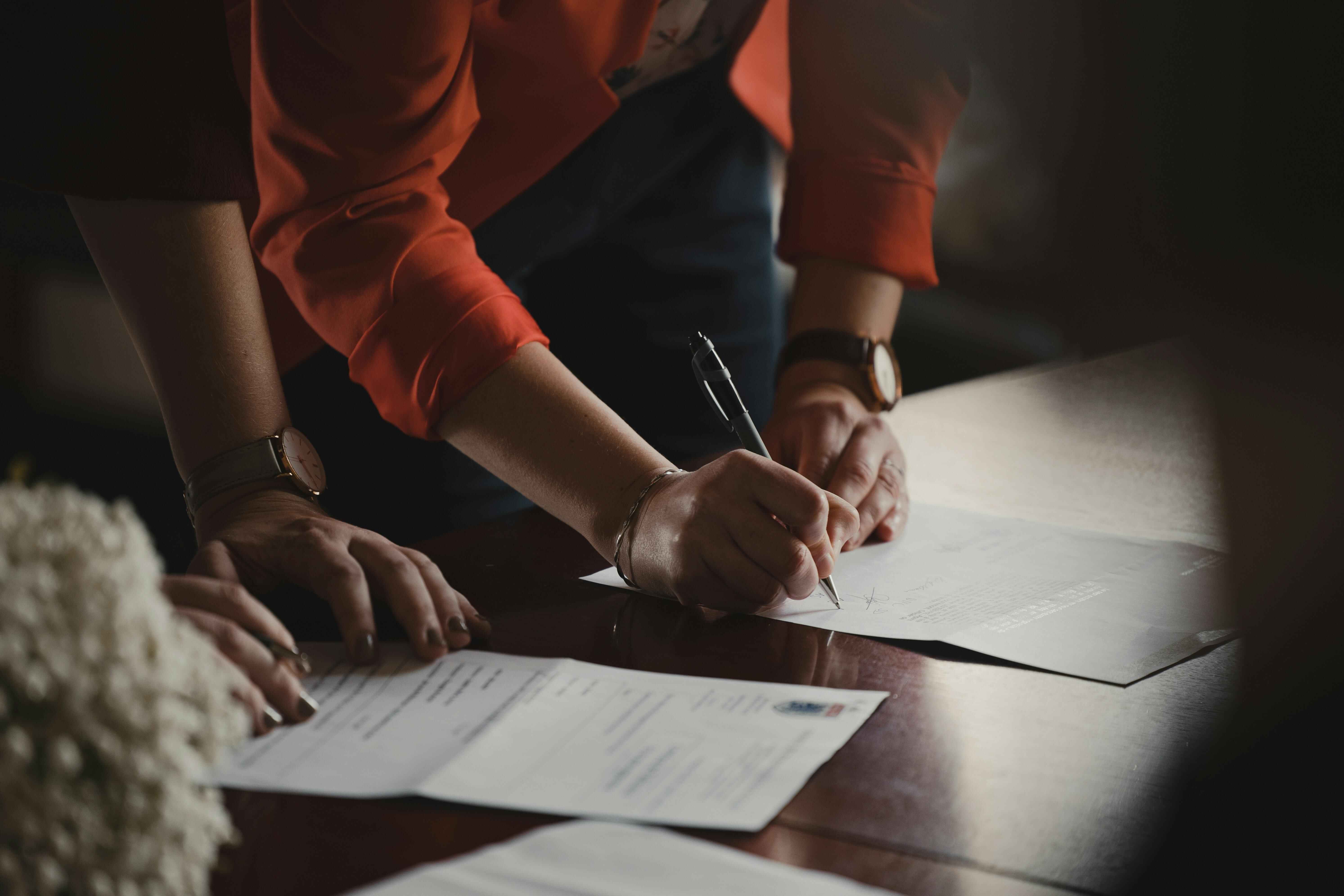 Image of people writing on paperwork