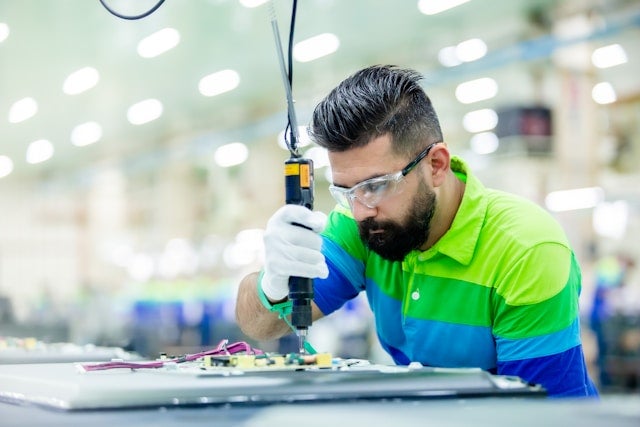 A technician manufacturing a circuit board
