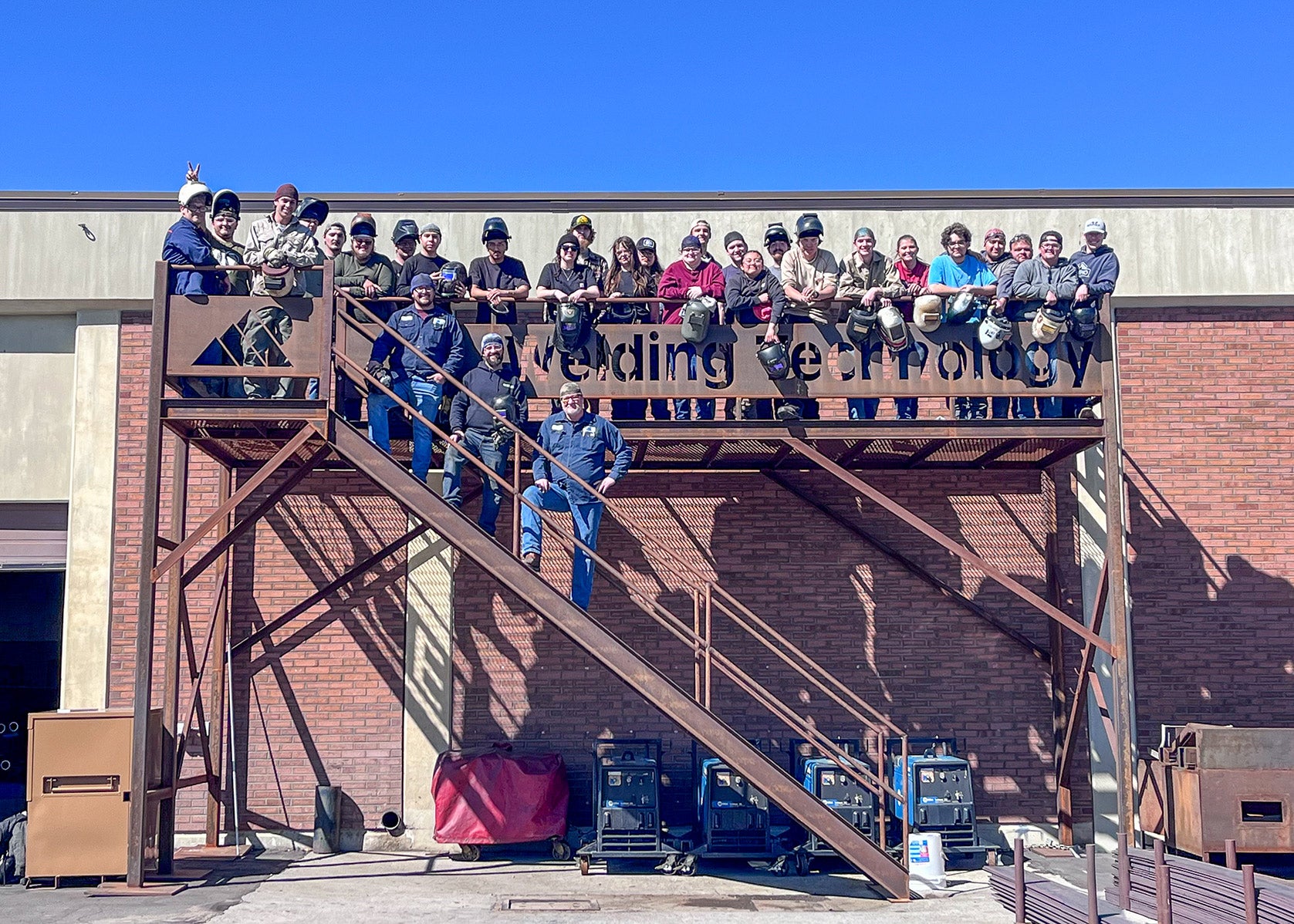 Welders pose on scaffolding