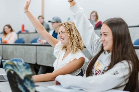 CEI Students raising hands