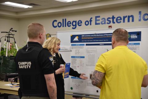 Student giving demonstration to onlookers