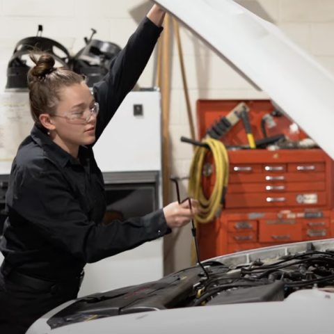 A student working on a car engine