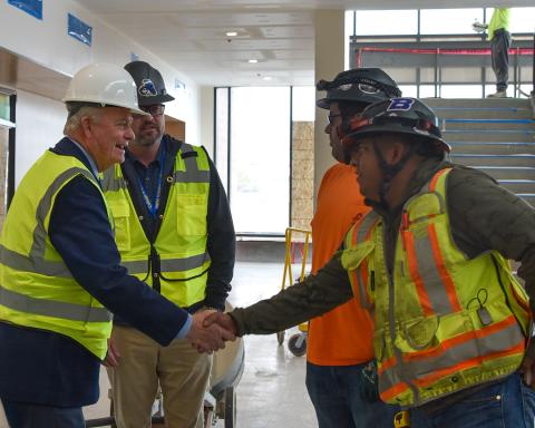 Governor Brad Little shakes hands with construction workers